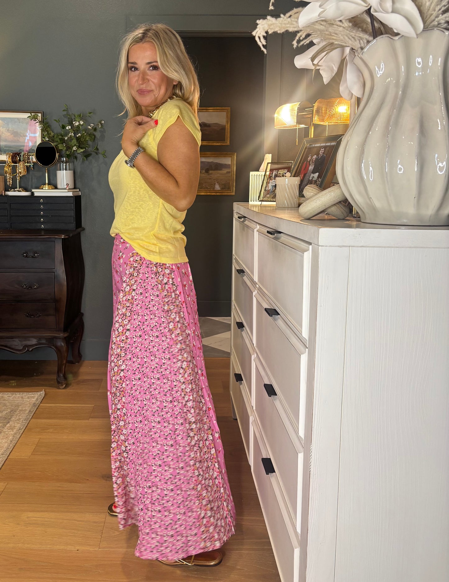 Woman in a yellow top and pink floral skirt