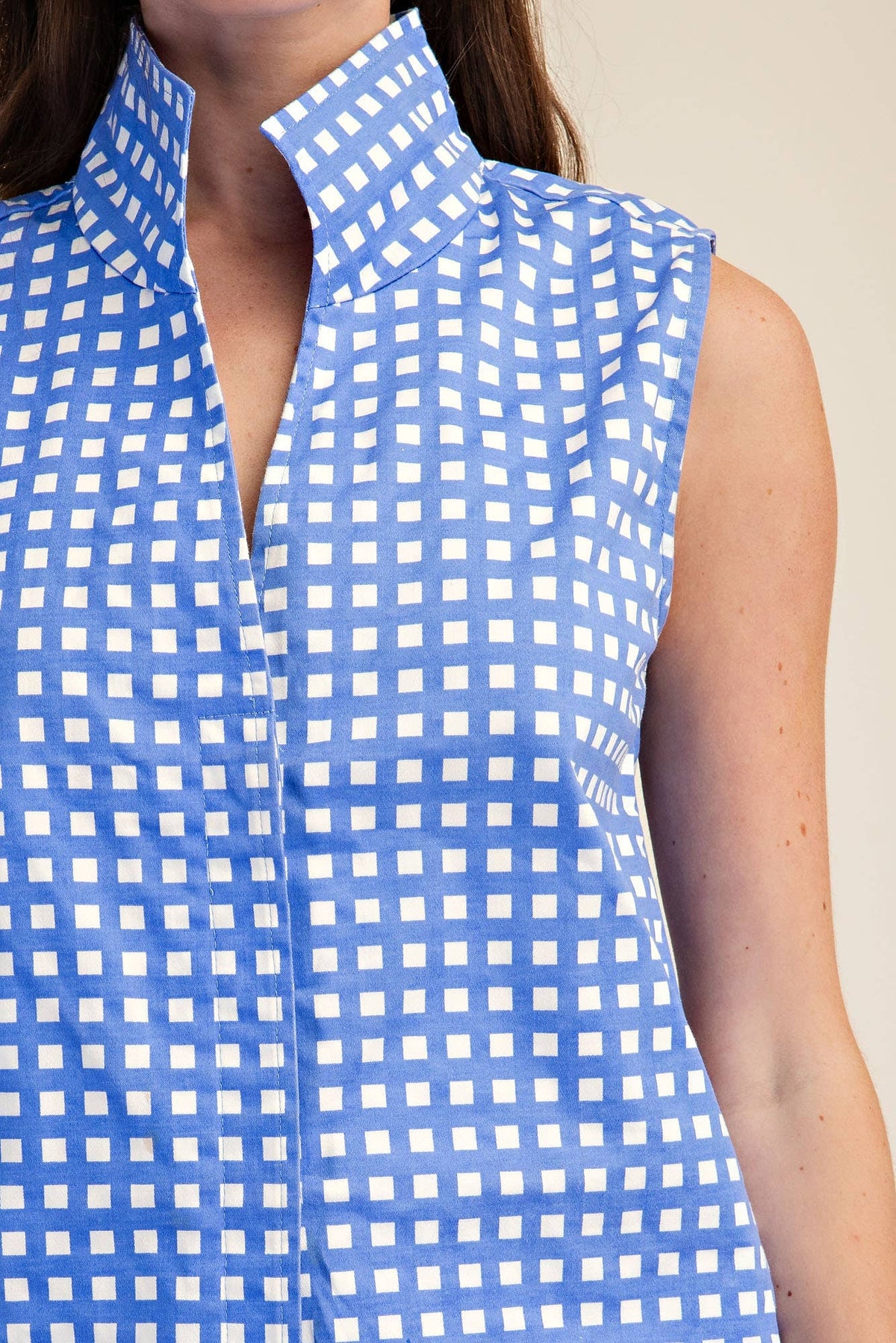 Blue and white checkered sleeveless top worn by a person.