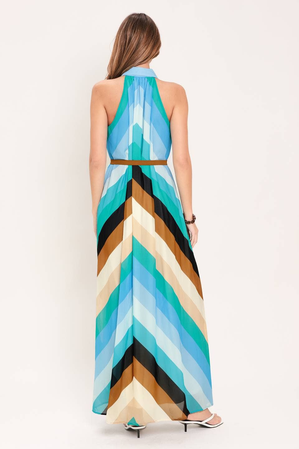 Woman wearing a colorful geometric-patterned dress on a white background