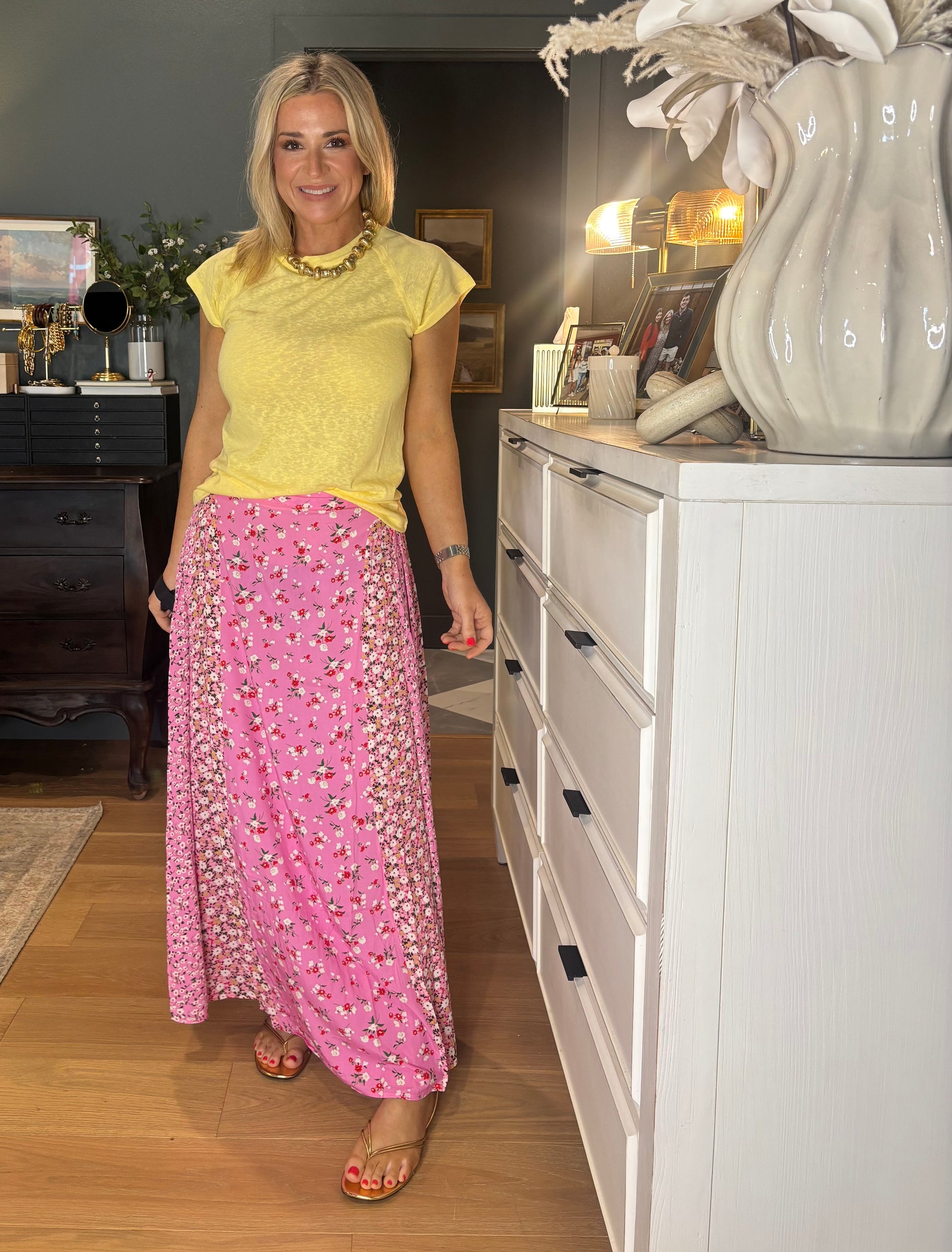 Woman in yellow top and pink floral skirt