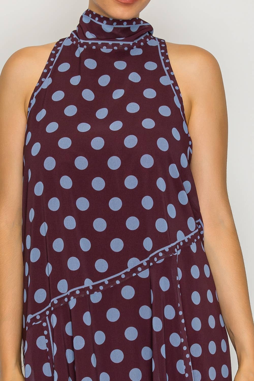 Woman wearing a polka dot dress with a plain background