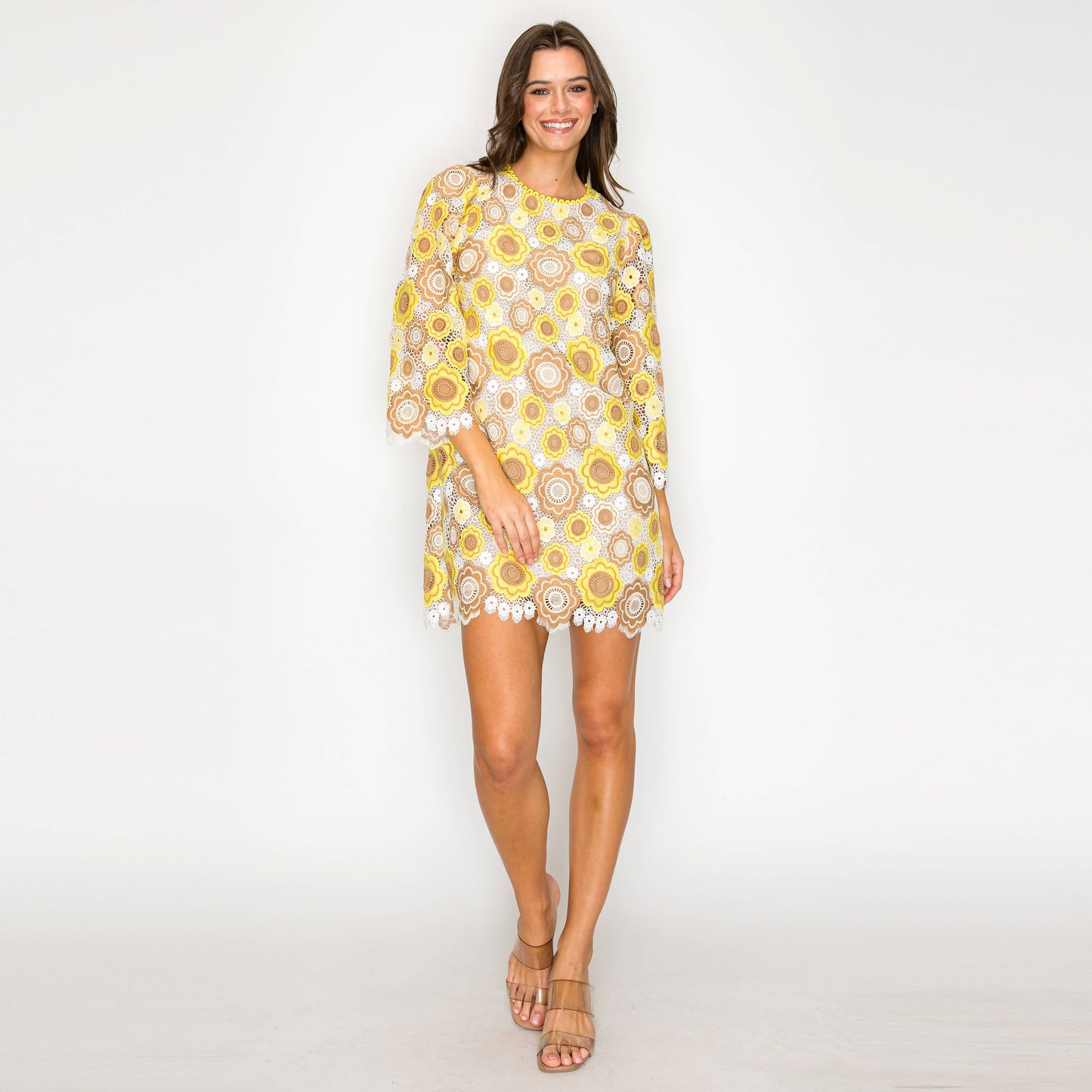 Woman wearing a yellow floral dress on a white background