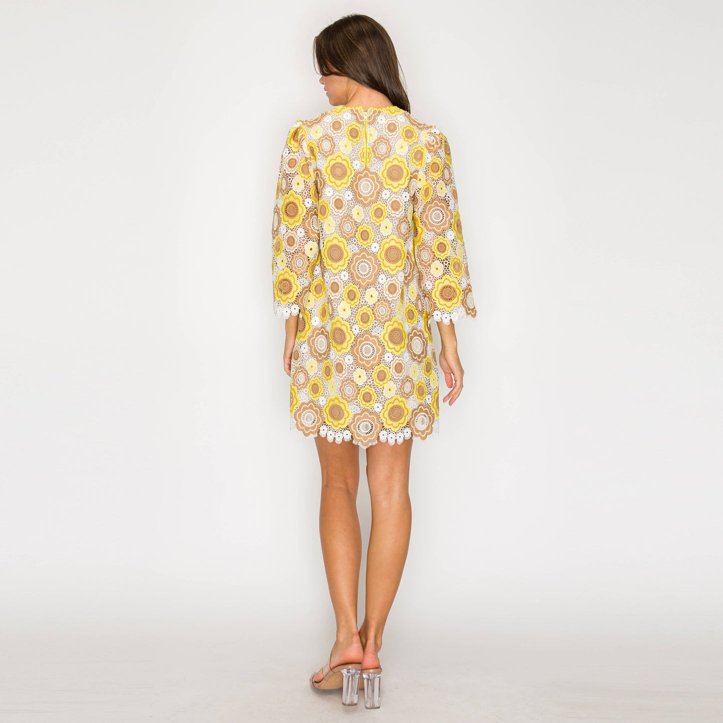 Woman wearing a yellow floral dress on a white background
