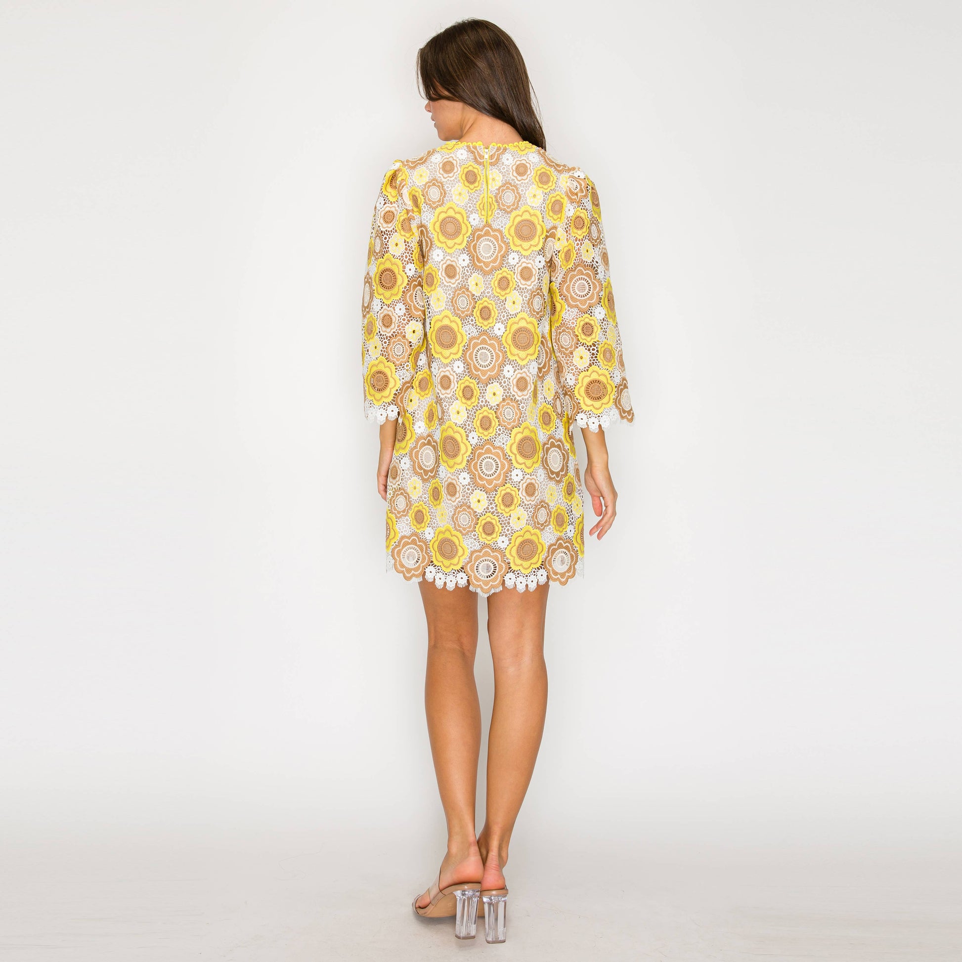Woman wearing a yellow floral dress on a white background