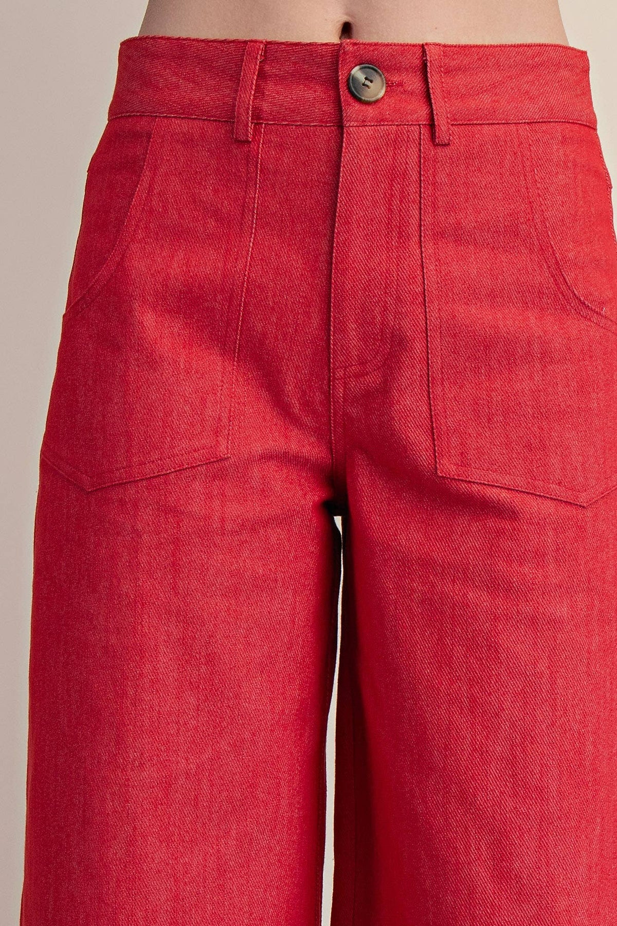 Red pants with a button on a neutral background