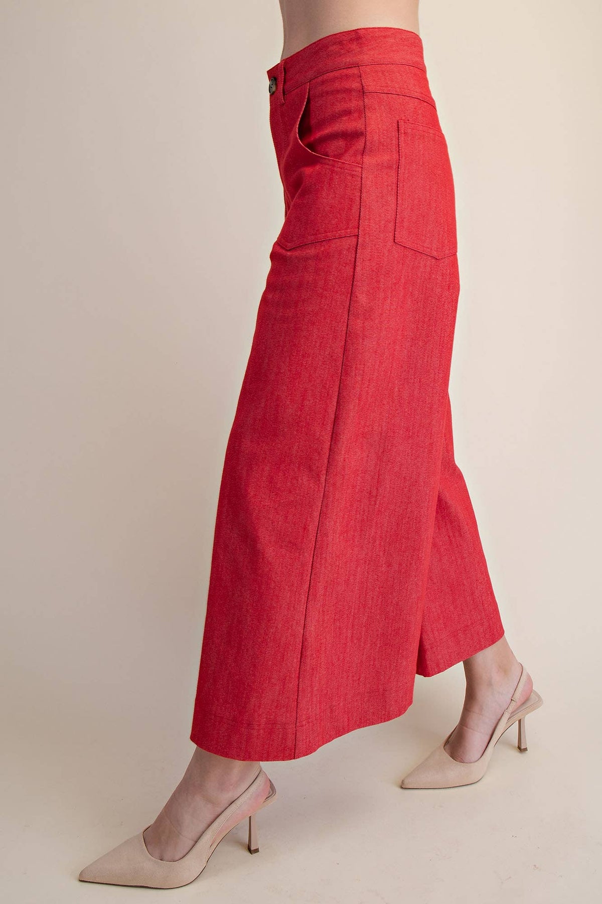 Red pants worn by a person on a beige background