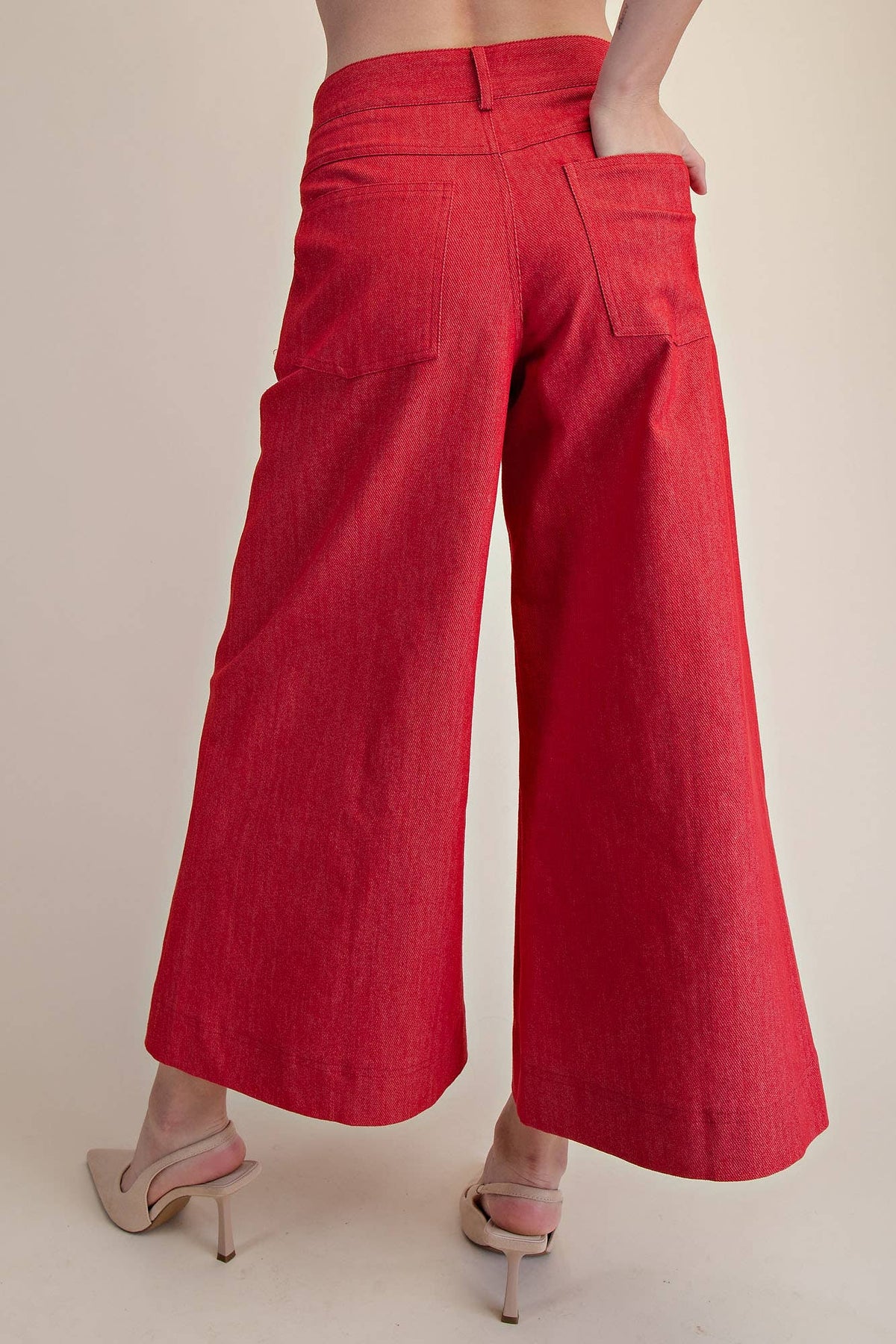 Red wide-leg pants worn by a person on a beige background