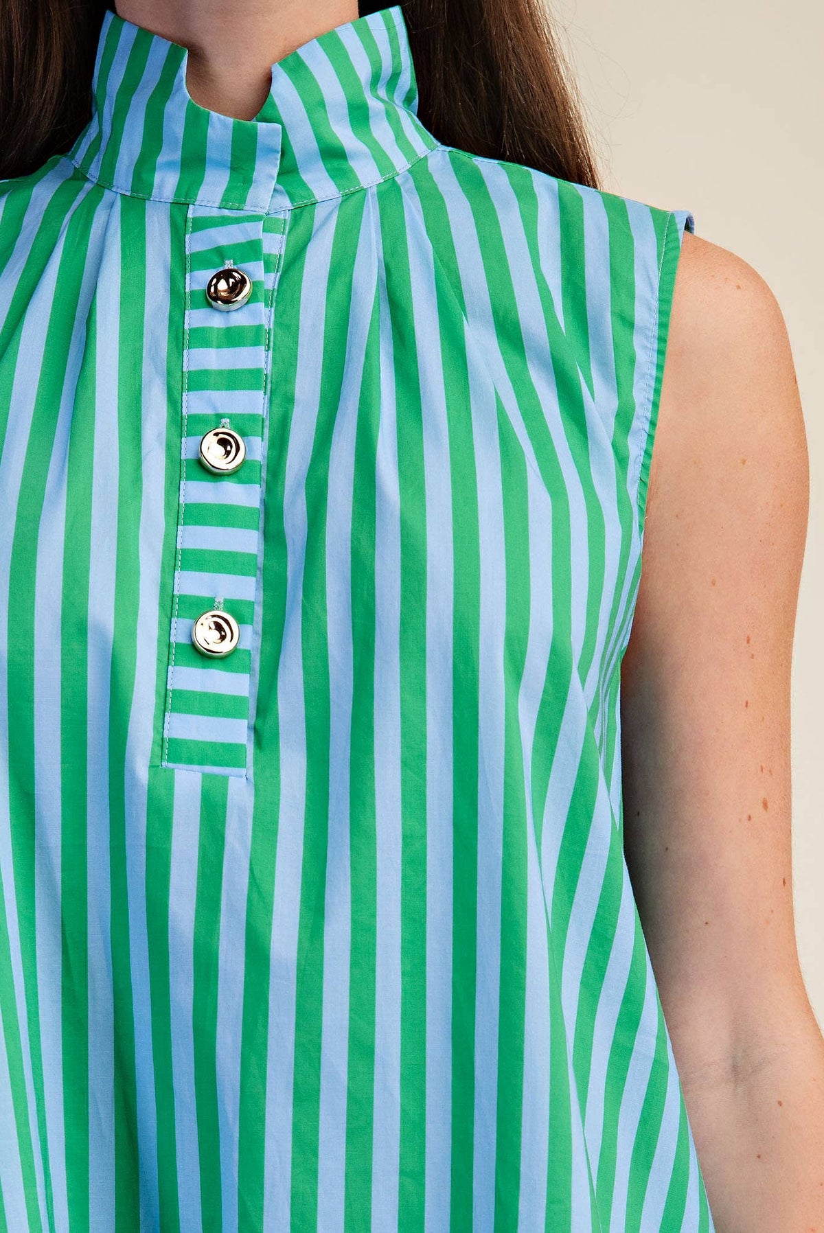 Green and blue striped sleeveless midi dress worn by a person.