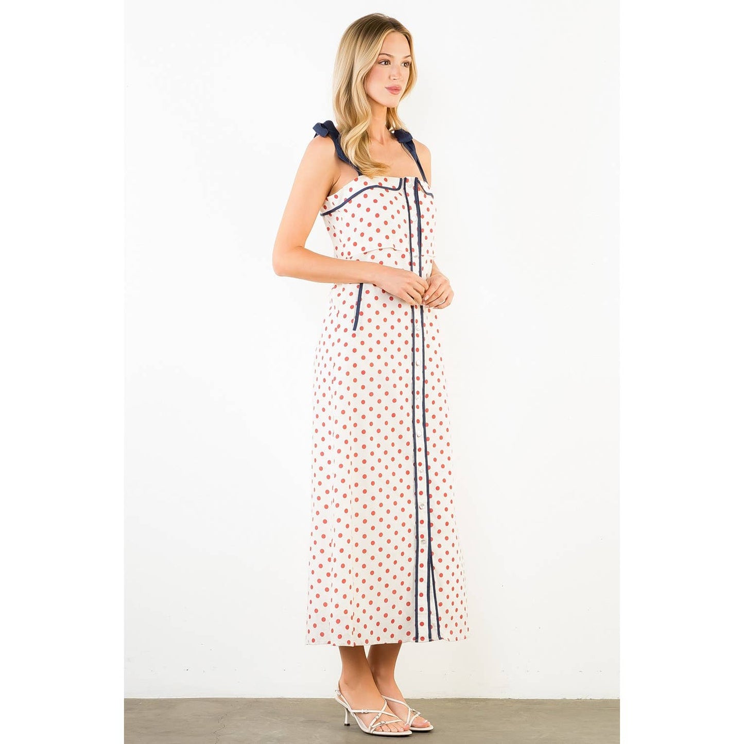 Woman wearing a polka dot dress with a white background
