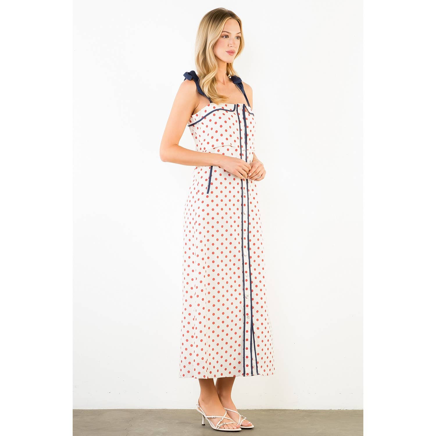 Woman wearing a polka dot dress with a white background