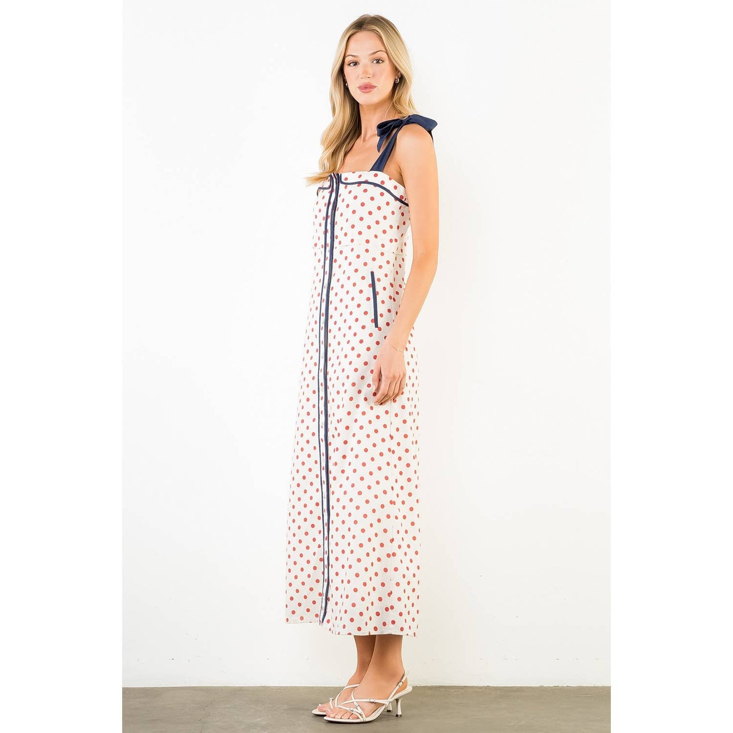 Woman wearing a polka dot dress with a white background