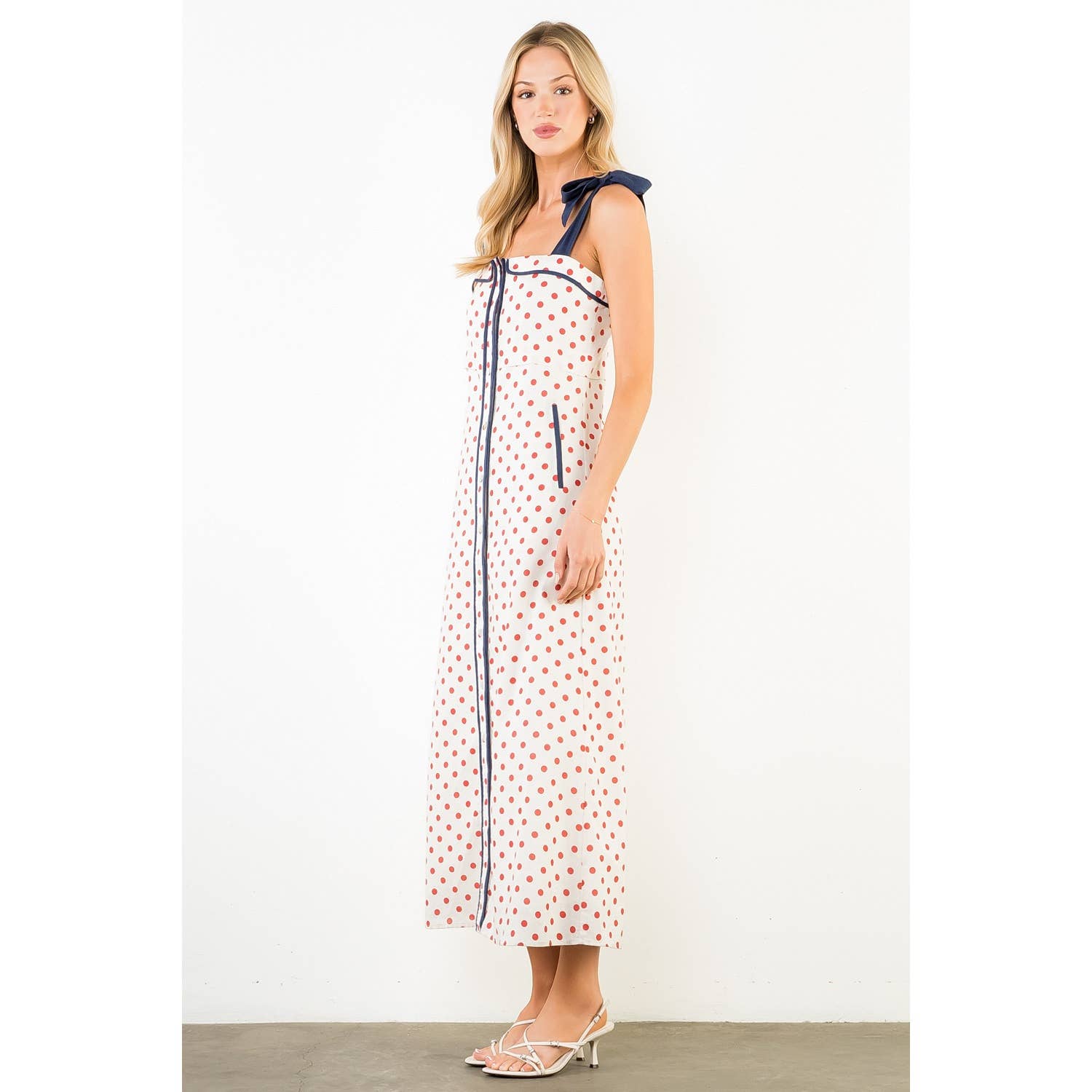 Woman wearing a polka dot dress with a white background