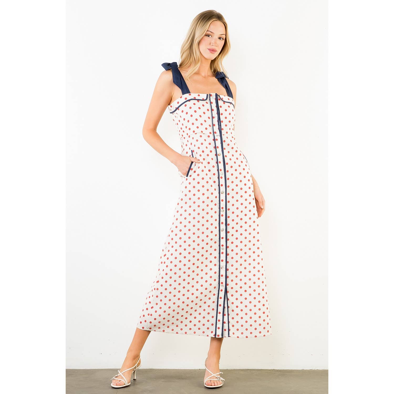 Woman wearing a polka dot dress with a white background