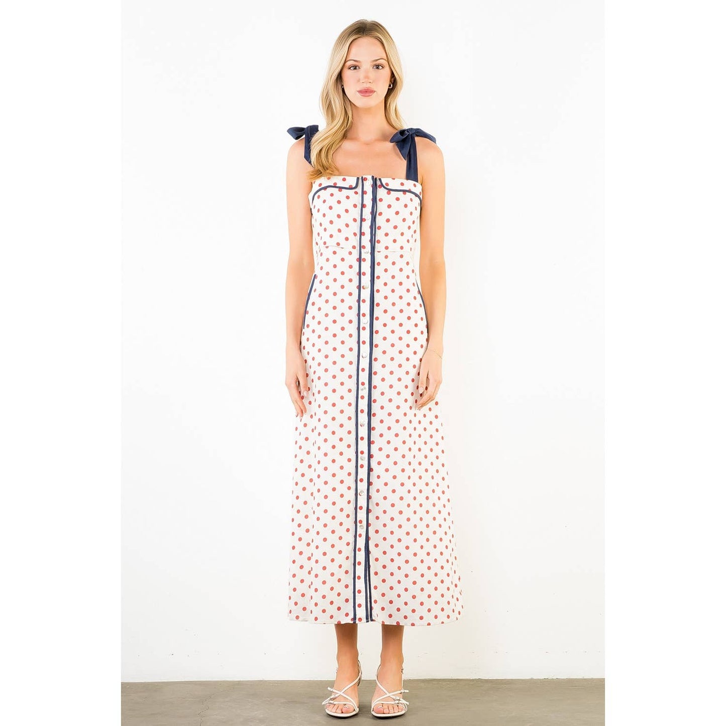 Woman wearing a polka dot dress with a white background