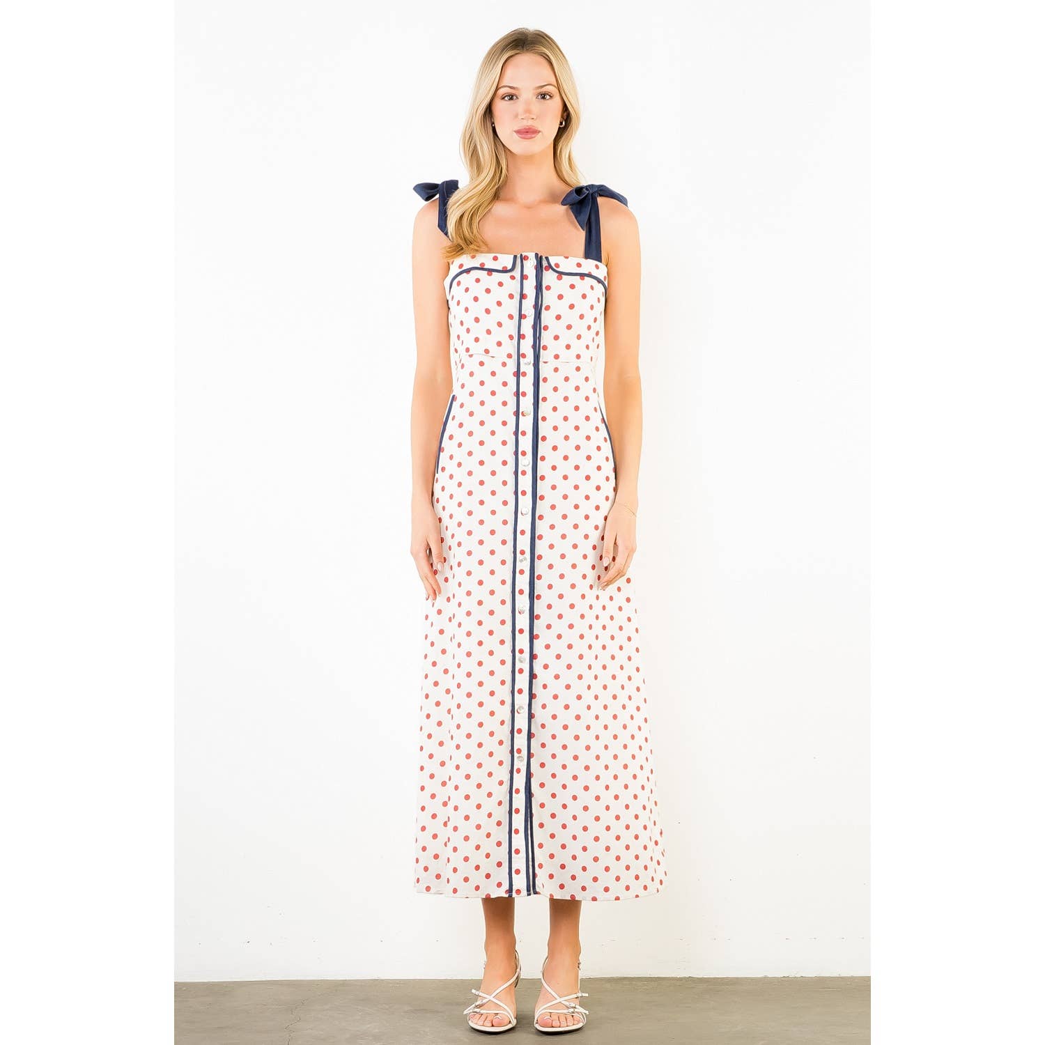 Woman wearing a polka dot dress with a white background